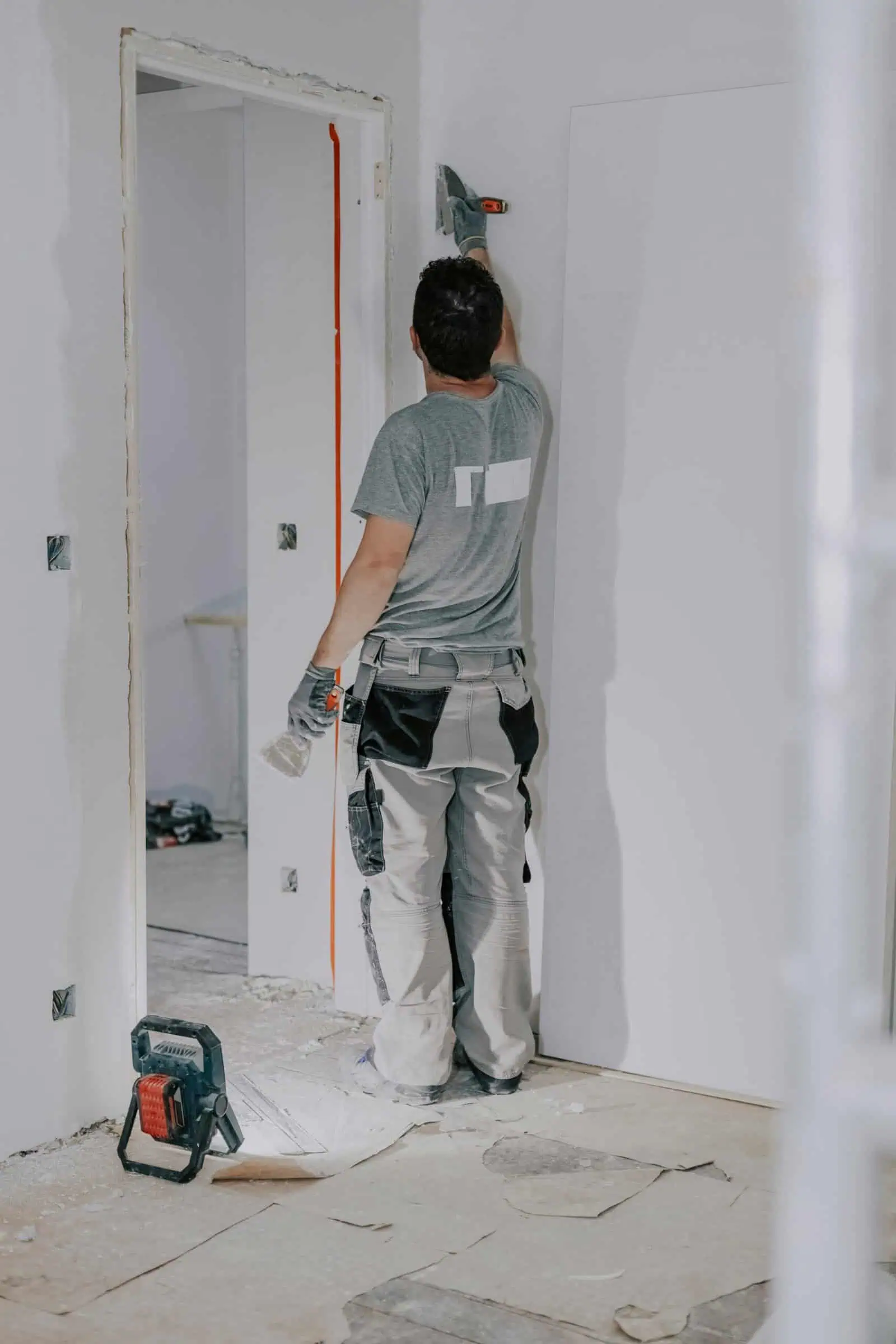 Drywall installer applying joint compound to wall seams.