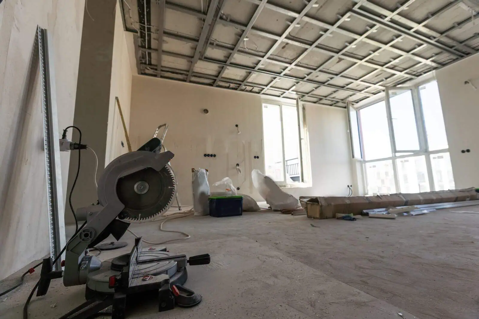 Interior drywall installation with construction tools and materials.